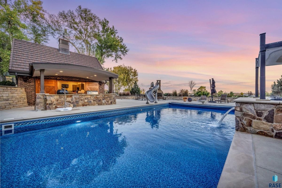 Pool with a slide and a grill area.