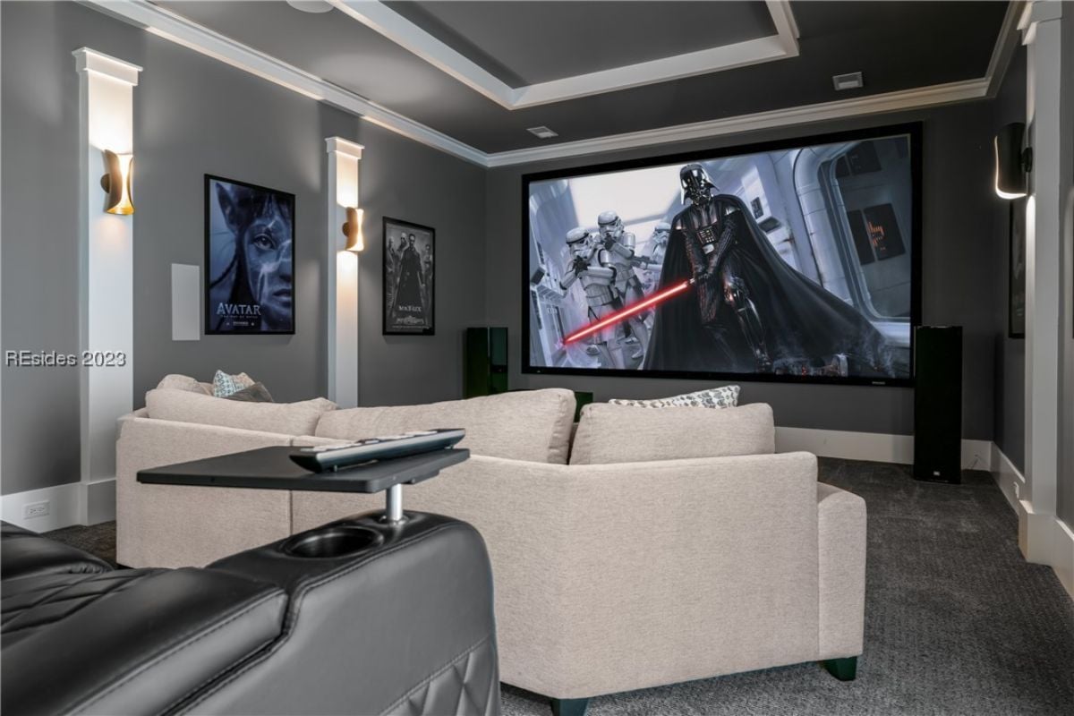Media room with couches and a large screen.