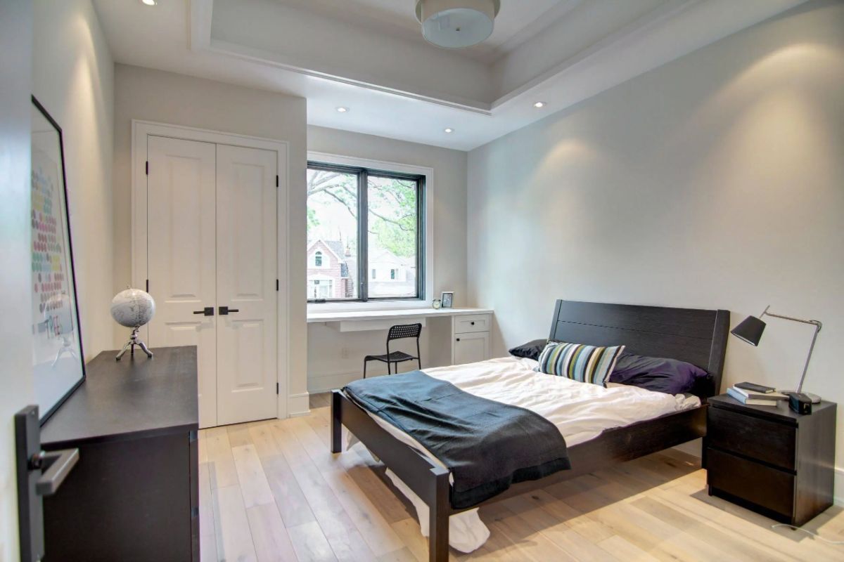 Bedroom with wood flooring, custom lighting and glass windows.