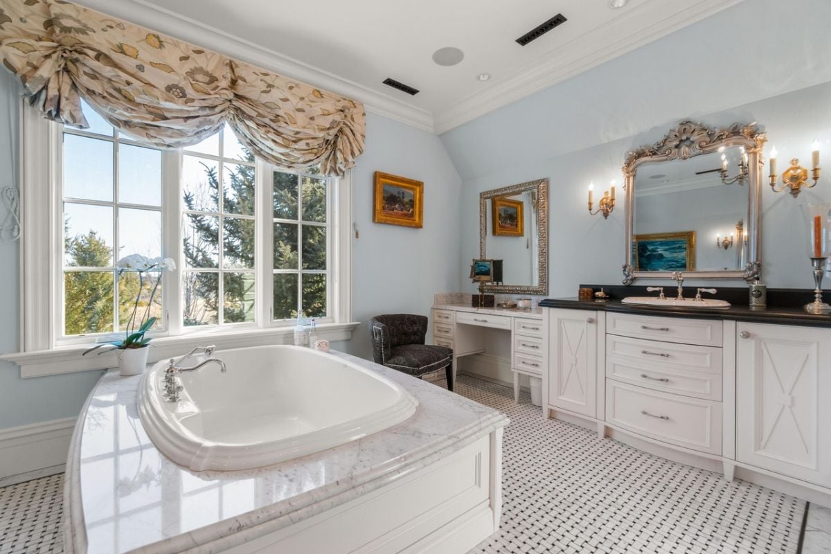 Bathroom with a soaking tub, sink and custom cabinetry.