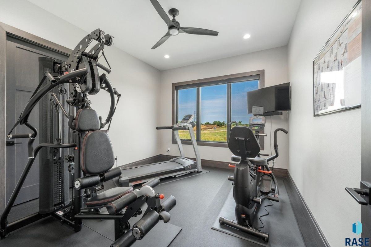 Home gym with workout equipment and glass windows.