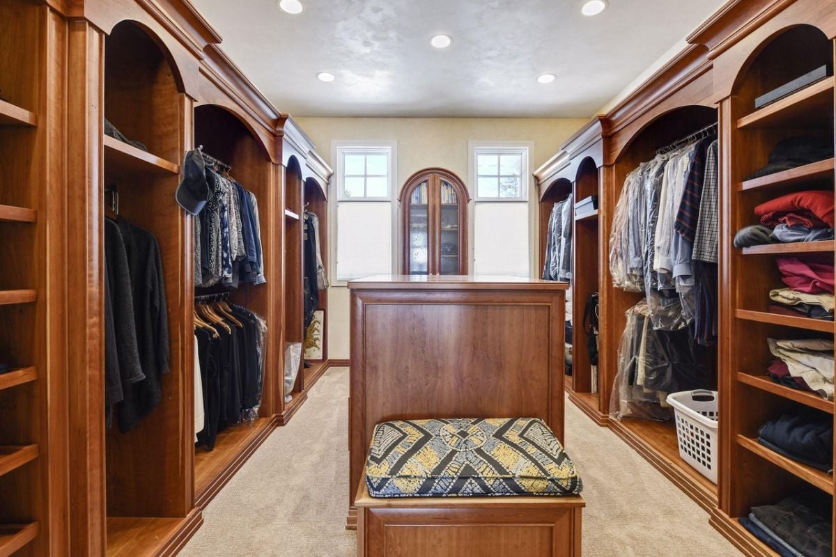 Walk-in closet with wooden cabinets and drawers.