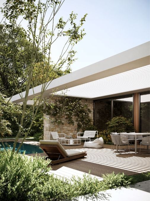A covered patio with bricks wall, table and chairs