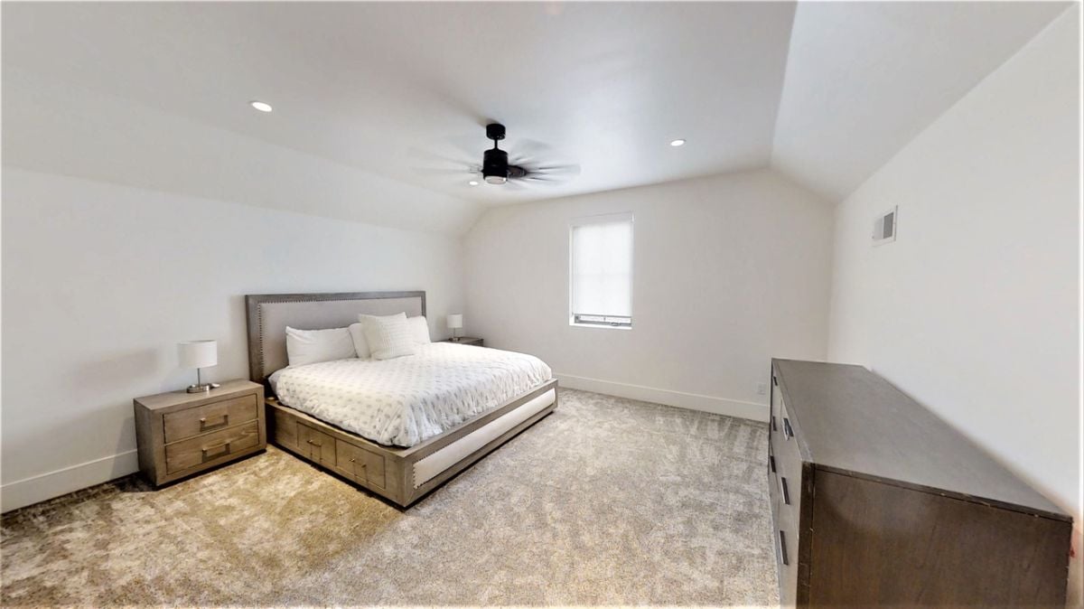 Bedroom with carpet flooring, custom lighting, and a ceiling fan.