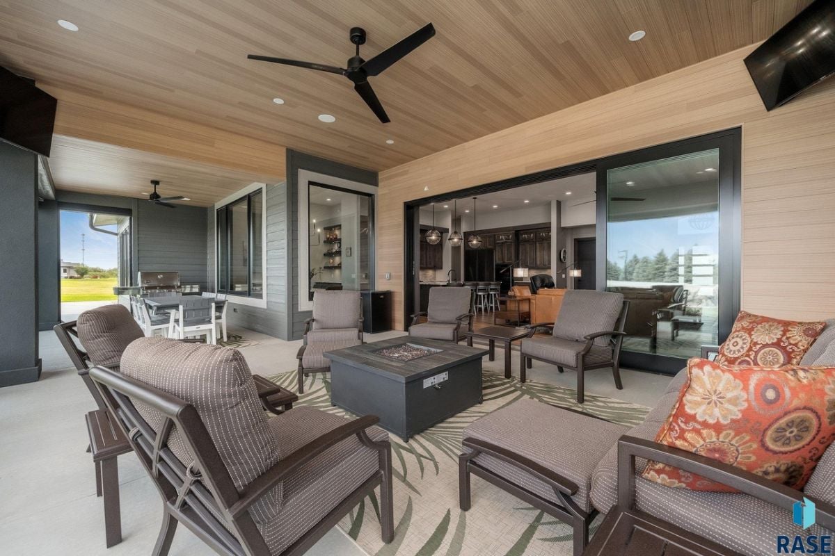 Patio with tables, chairs, a ceiling fan and a television.
