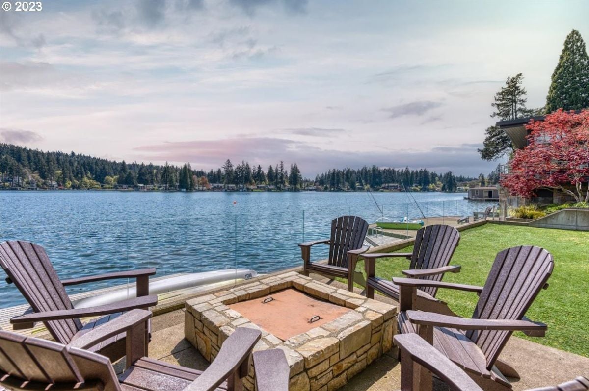 Patio with chairs, fire pit, and a view of the lake.
