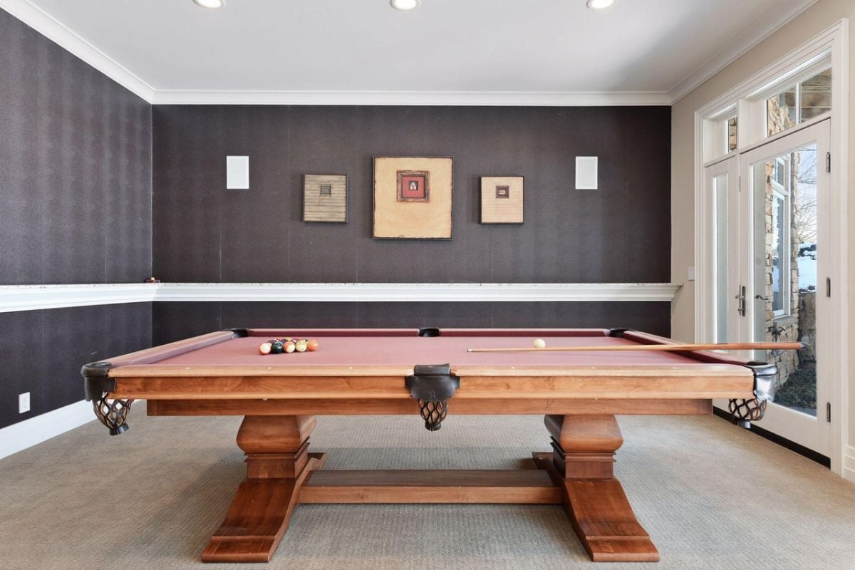 Billiards room with carpet flooring and glass doors.
