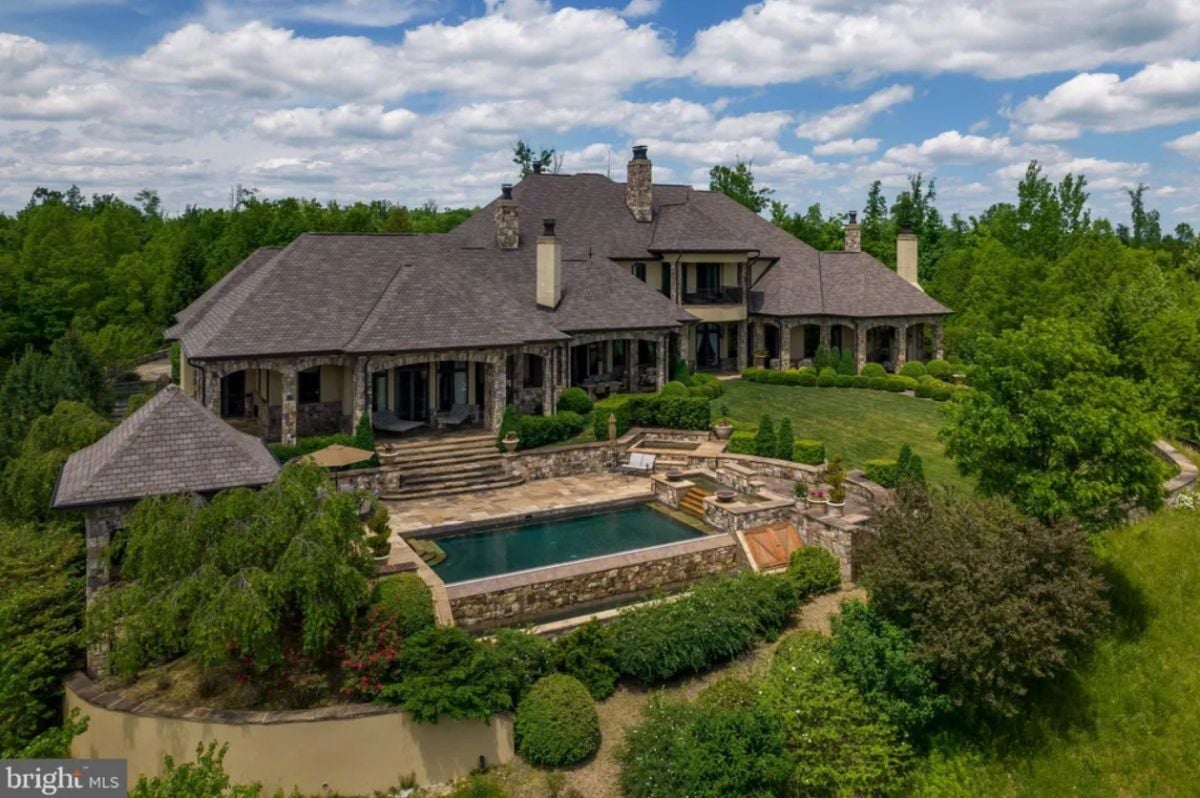 Rear view of the house with a pool and a large backyard.