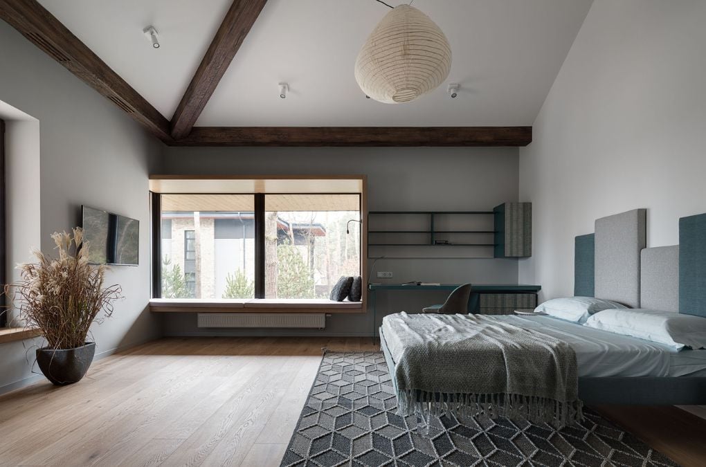 A large bedroom with study area and large glass window