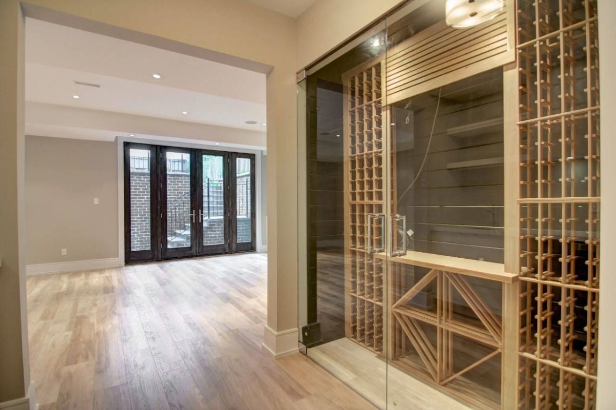 Wine cellar with a glass door and a wooden floor.