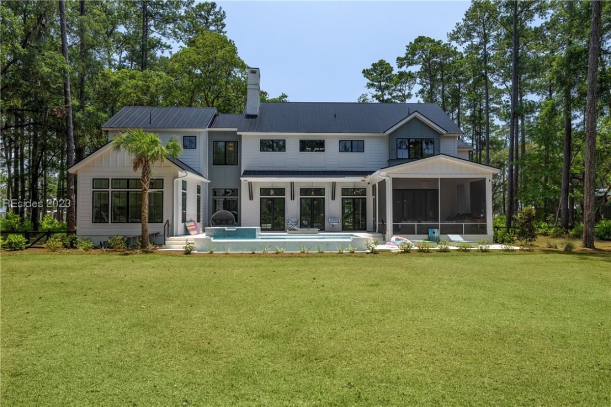 Rear view of the property with a large green lawn.