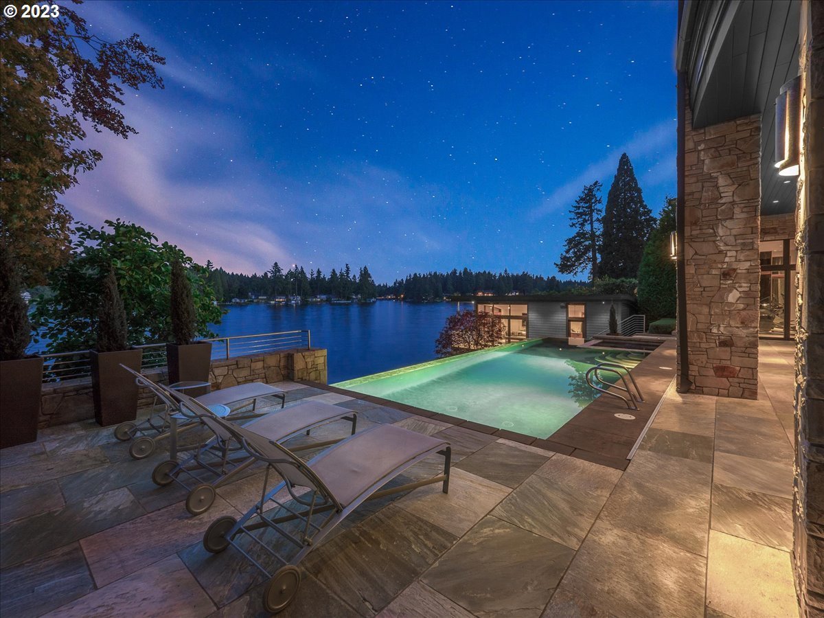 Pool with lounge chairs and a view of the lake.