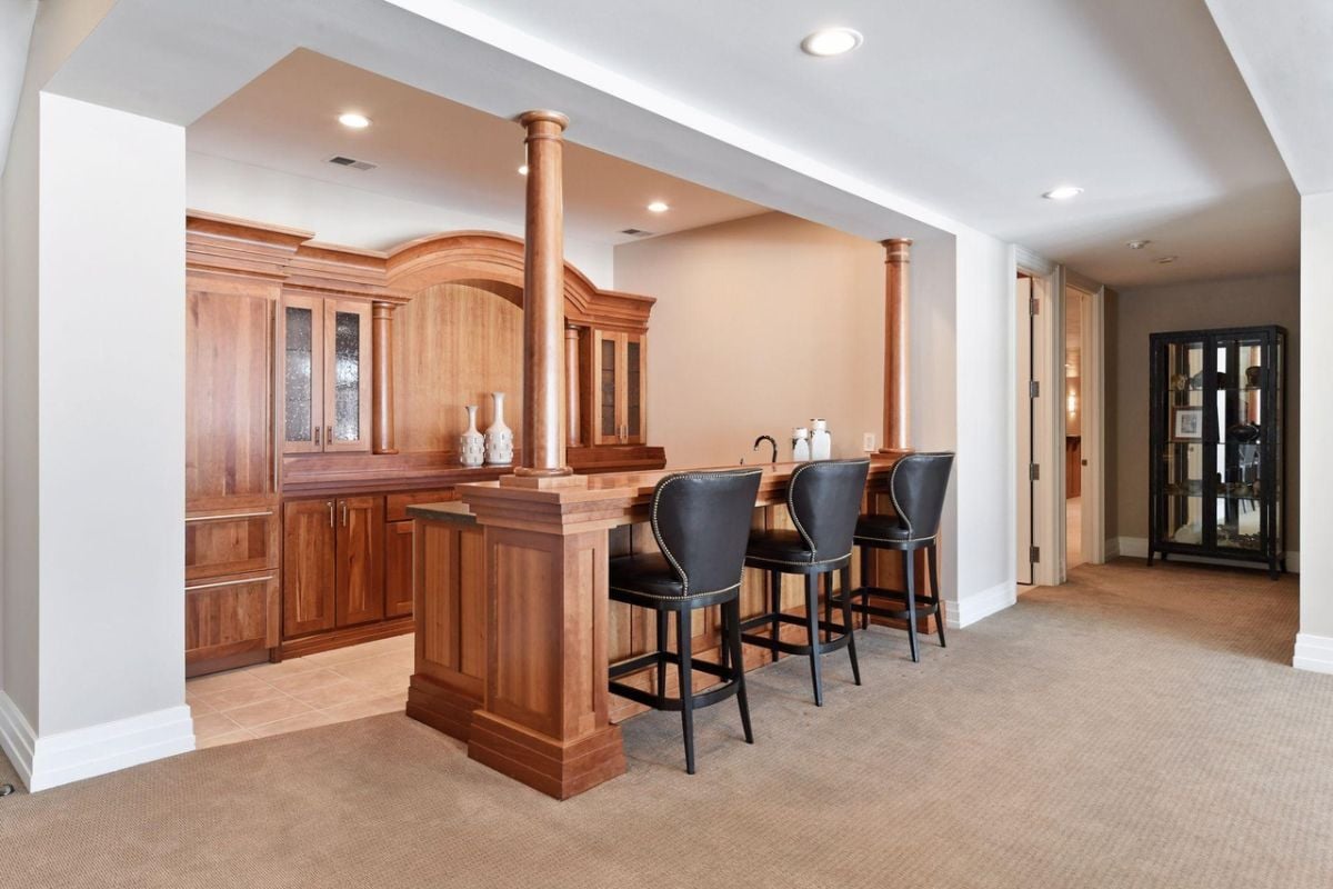 Bar with custom cabinetry, counter, and high chairs.