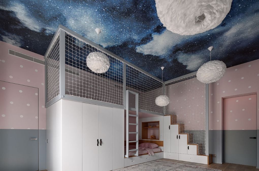 A child's bedroom with a mural of a night sky