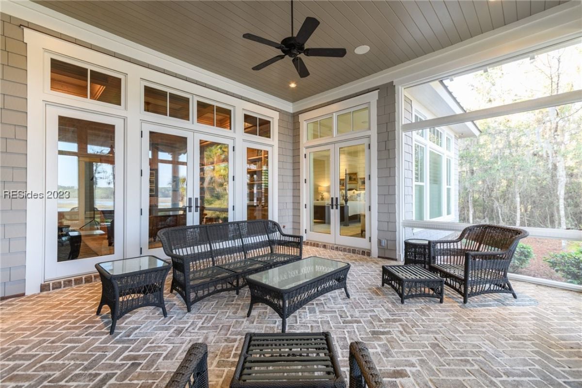 Patio with a ceiling fan, chairs and a table.