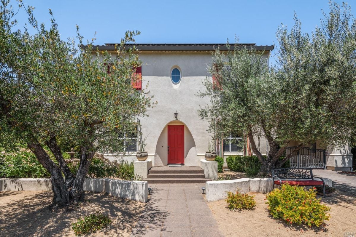 Formal entry of the house with a red door.