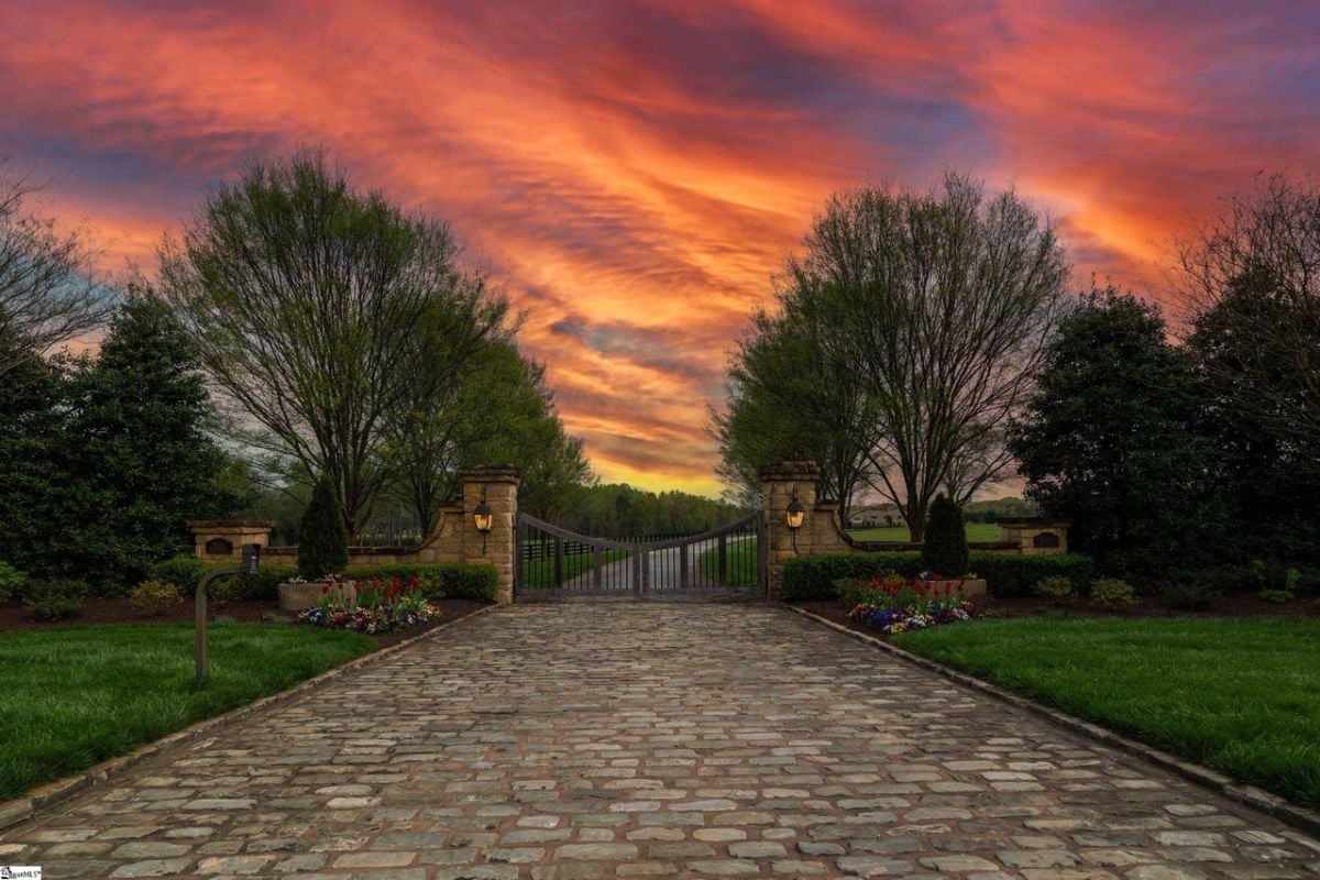 Main gate of the house with a colorful sky in the background.