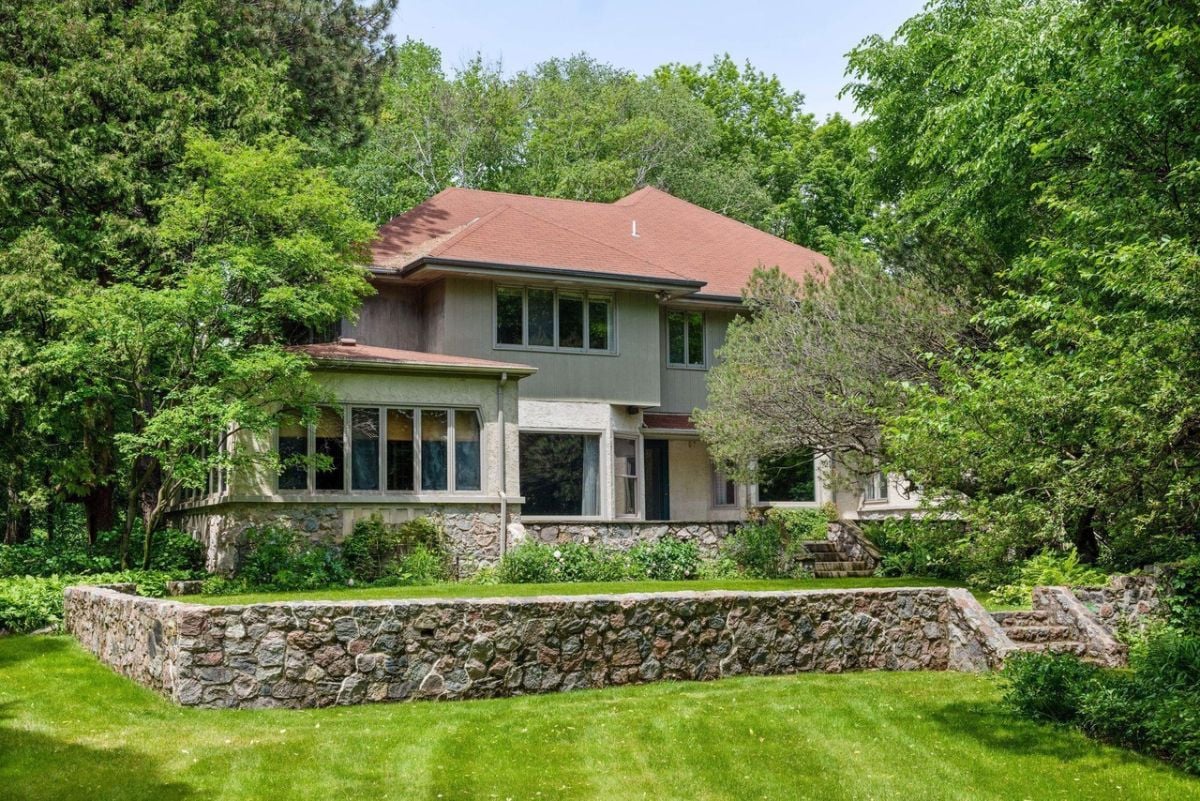 Rear view of the house with green lawn and trees.