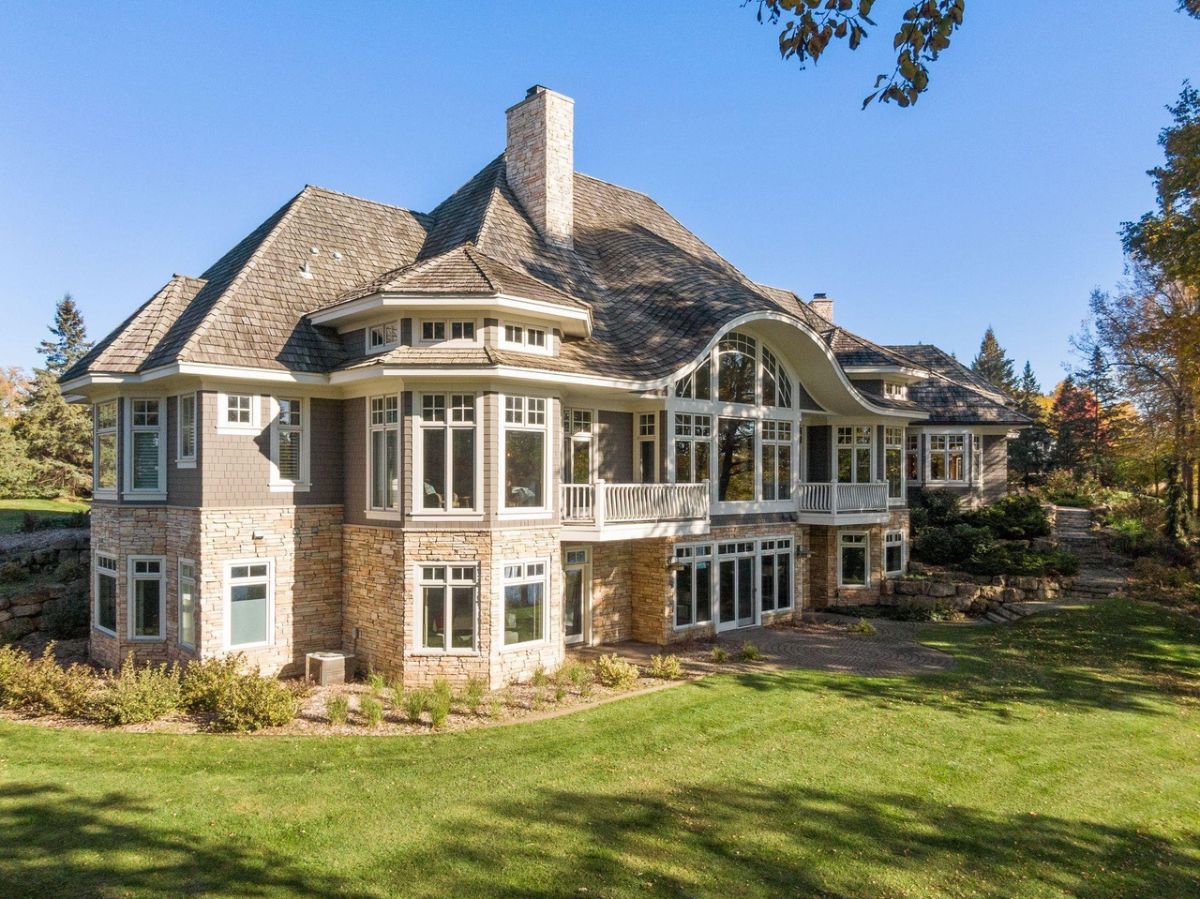 Rear view of the house with a large green lawn.