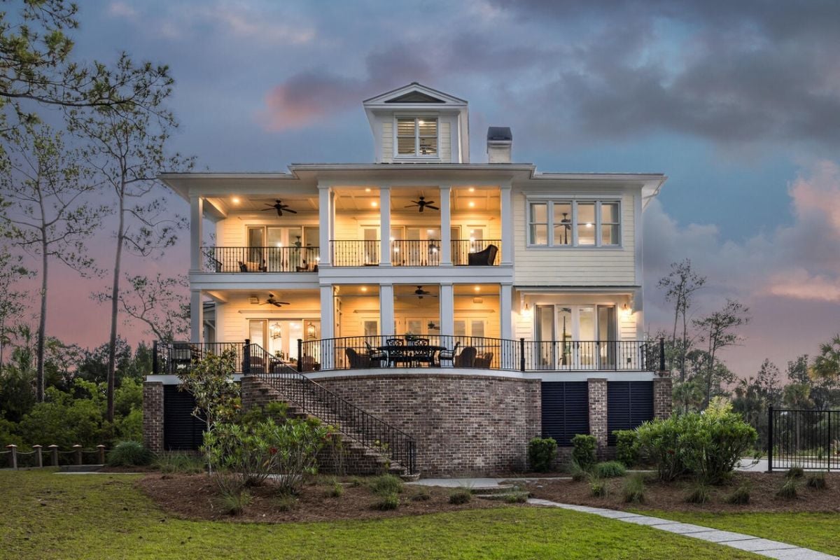 Rear view of the house with a balcony and a backyard lawn.