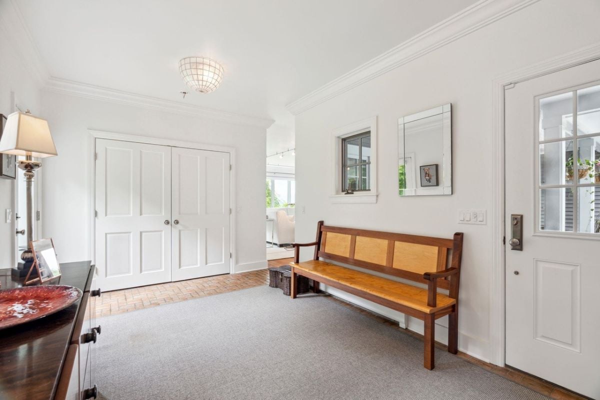 Foyer with a wooden bench and a mirror.