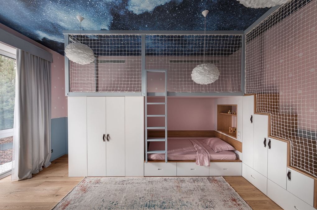 A child's bedroom with a space theme painted on the ceiling