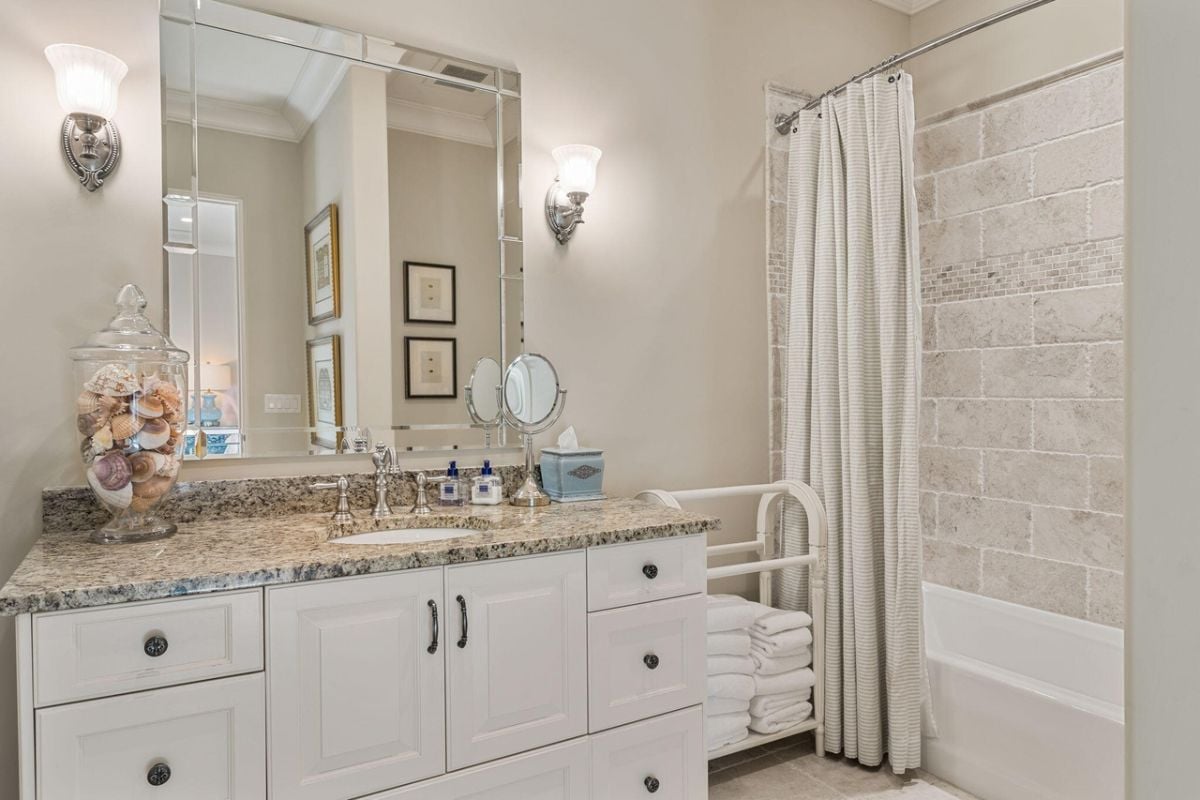 Bathroom with a sink, custom lighting and a bath tub.