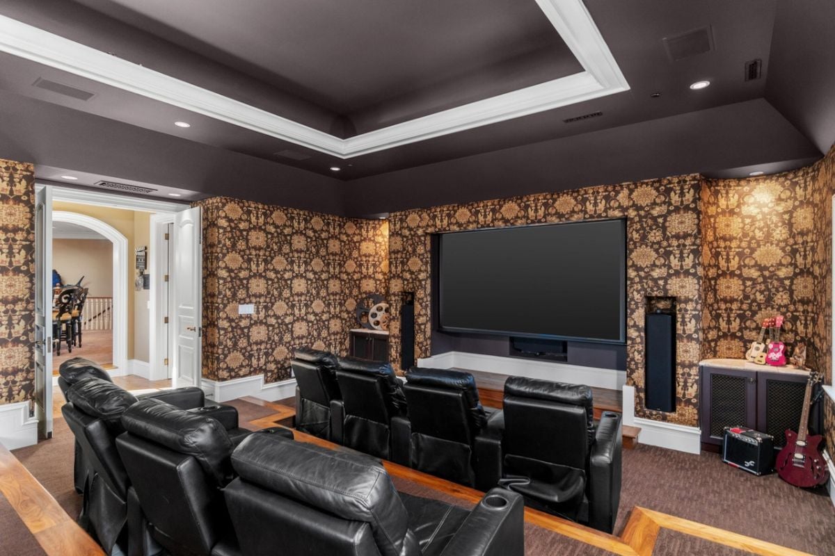 Media room with leather couches and a large flat screen TV.