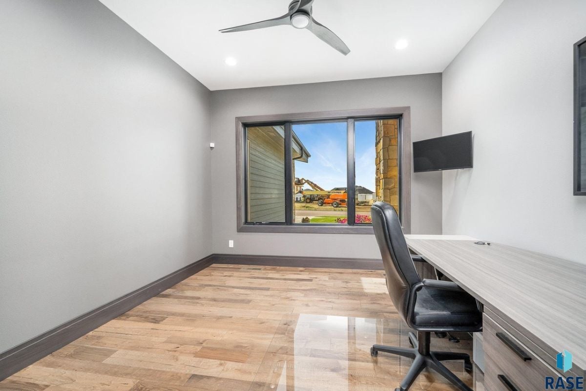 Home office with chair, desk and a ceiling fan.