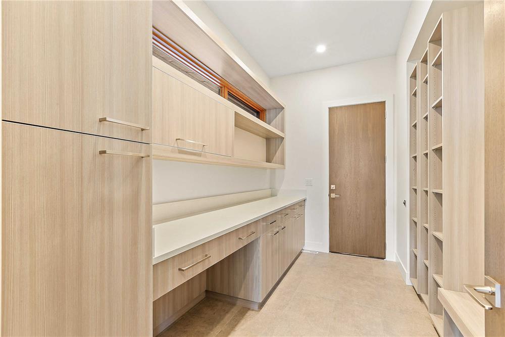 Mudroom with a built-in desk, cubbies, and wooden cabinets.