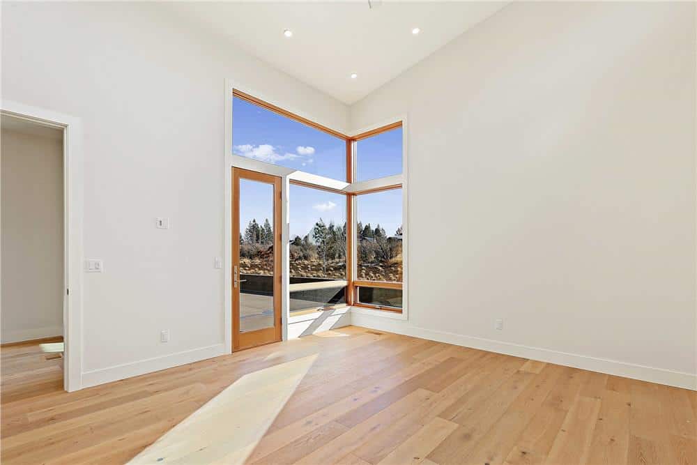 Primary bedroom with hardwood flooring, an ensuite bath, and outdoor access.