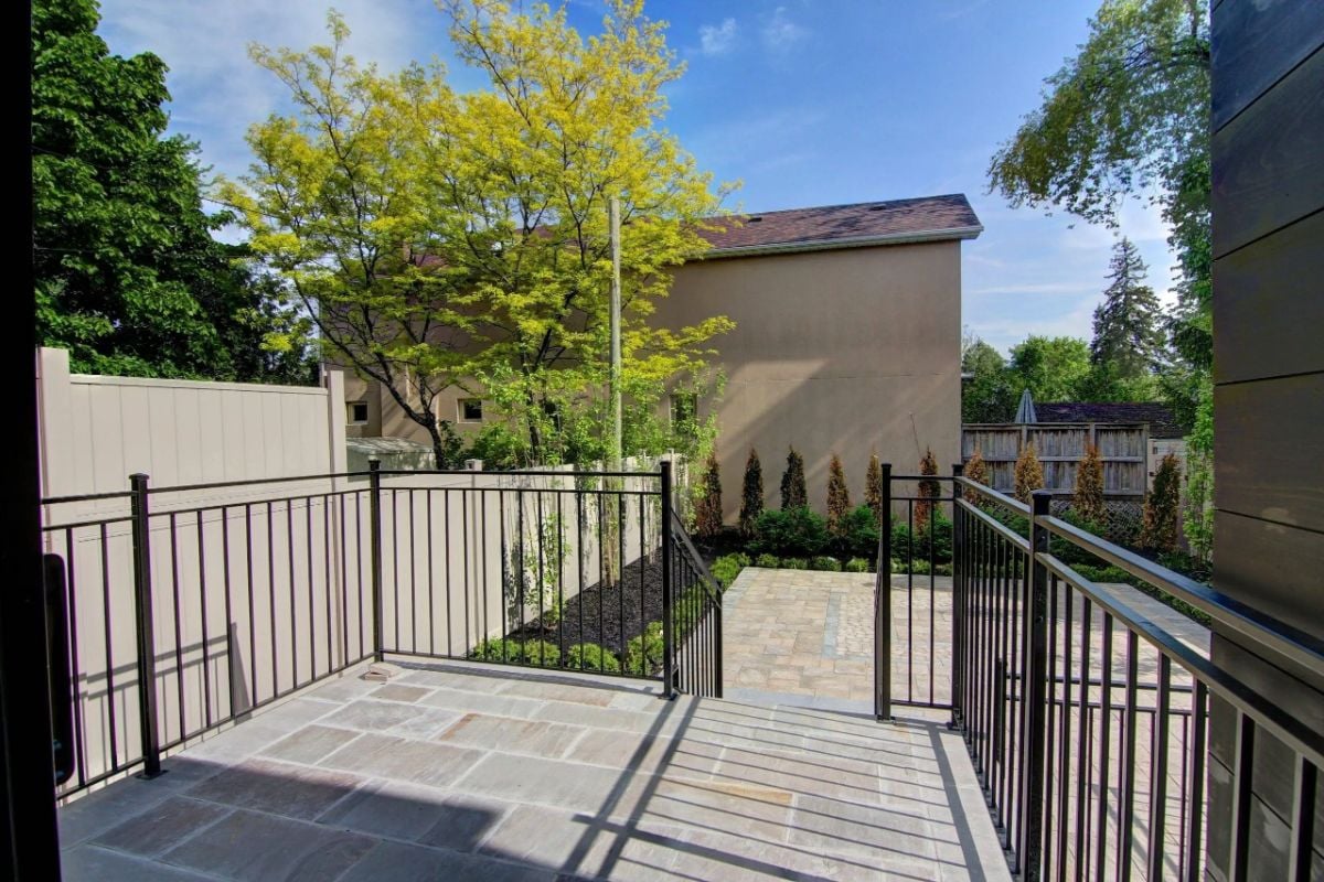 Backyard porch with metal railings.