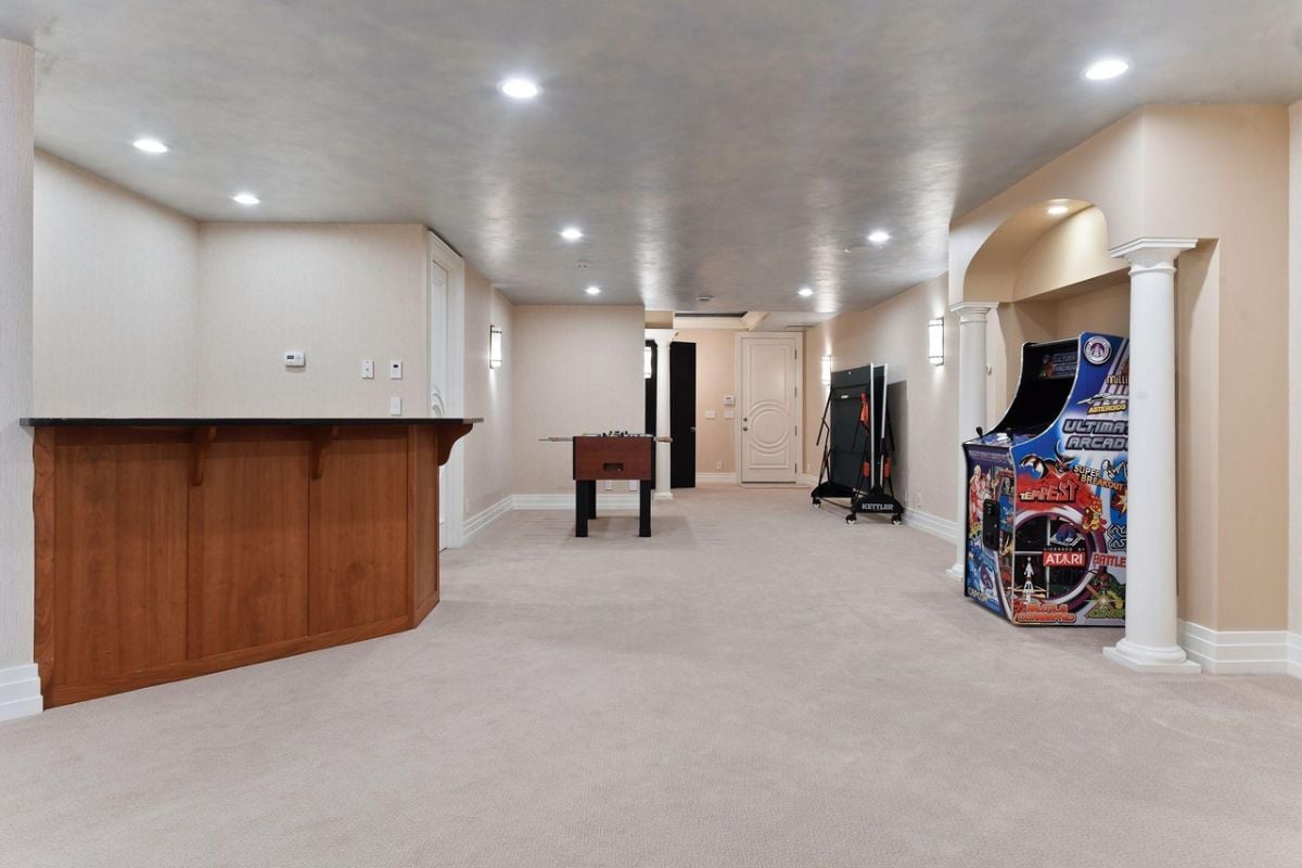 Recreation room with carpet flooring and custom lighting.
