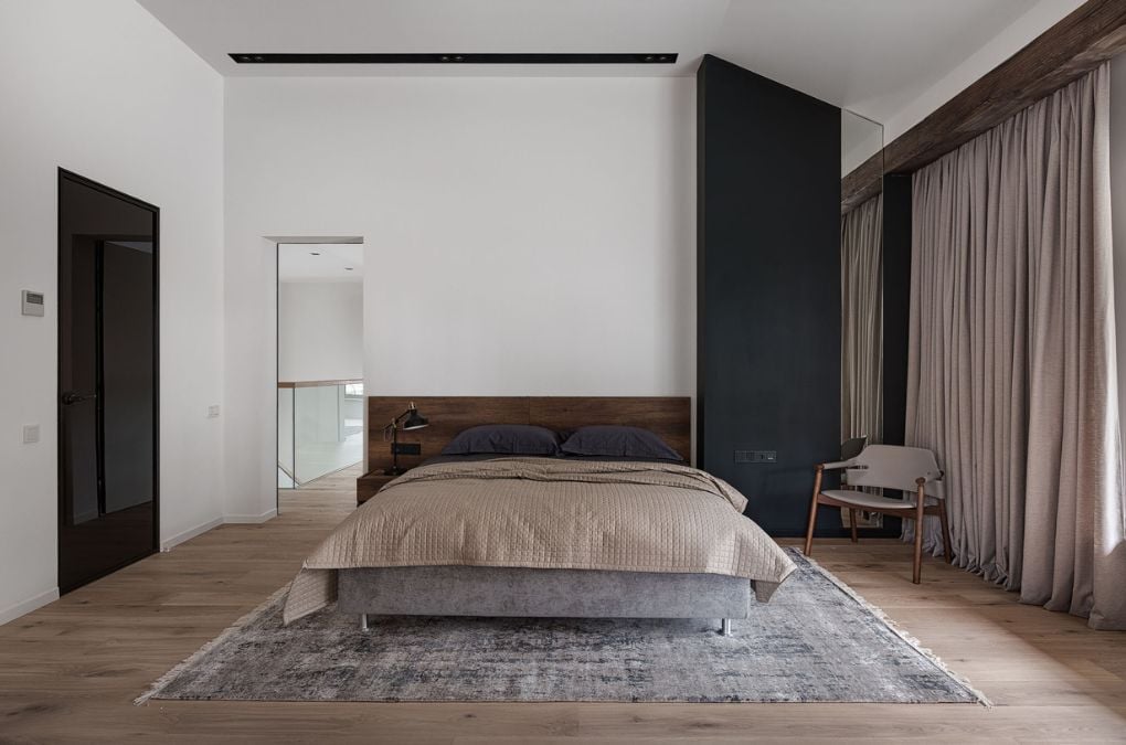 A large bedroom with white walls and wooden flooring