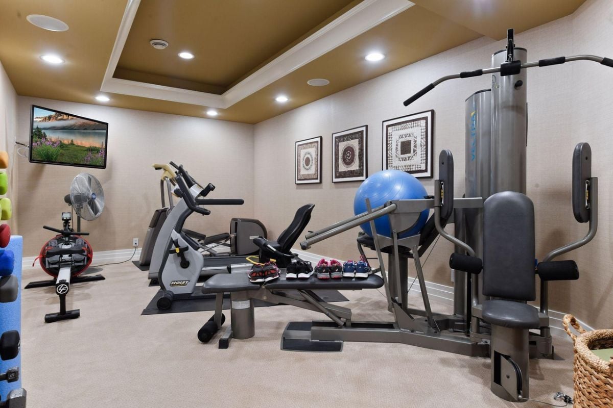 Home gym with carpet flooring and workout equipment.