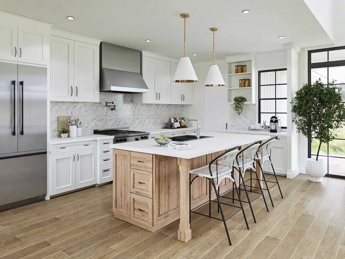 Kitchen with white cabinets, stainless steel appliances, marble countertops, and a breakfast island with three seating.