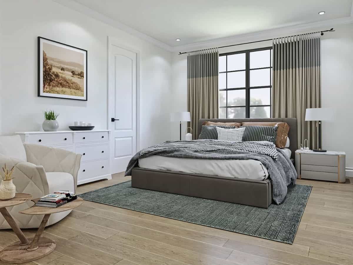 Primary bedroom with an upholstered bed, a white dresser, and a beige armchair paired with a wooden side table.