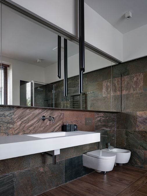 A bathroom with a sink, mirror and toilet
