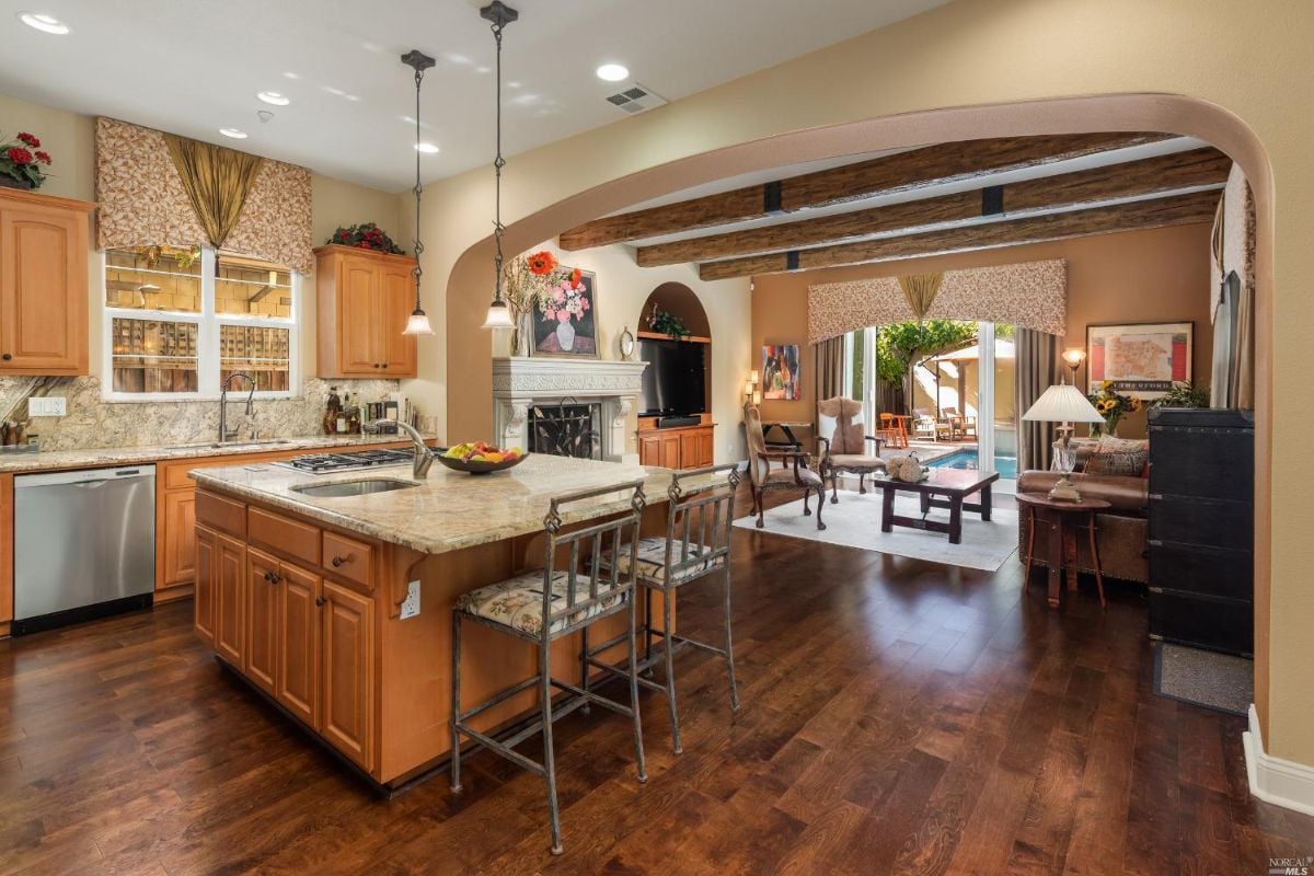 Kitchen with wood flooring, a large island and granite countertops.