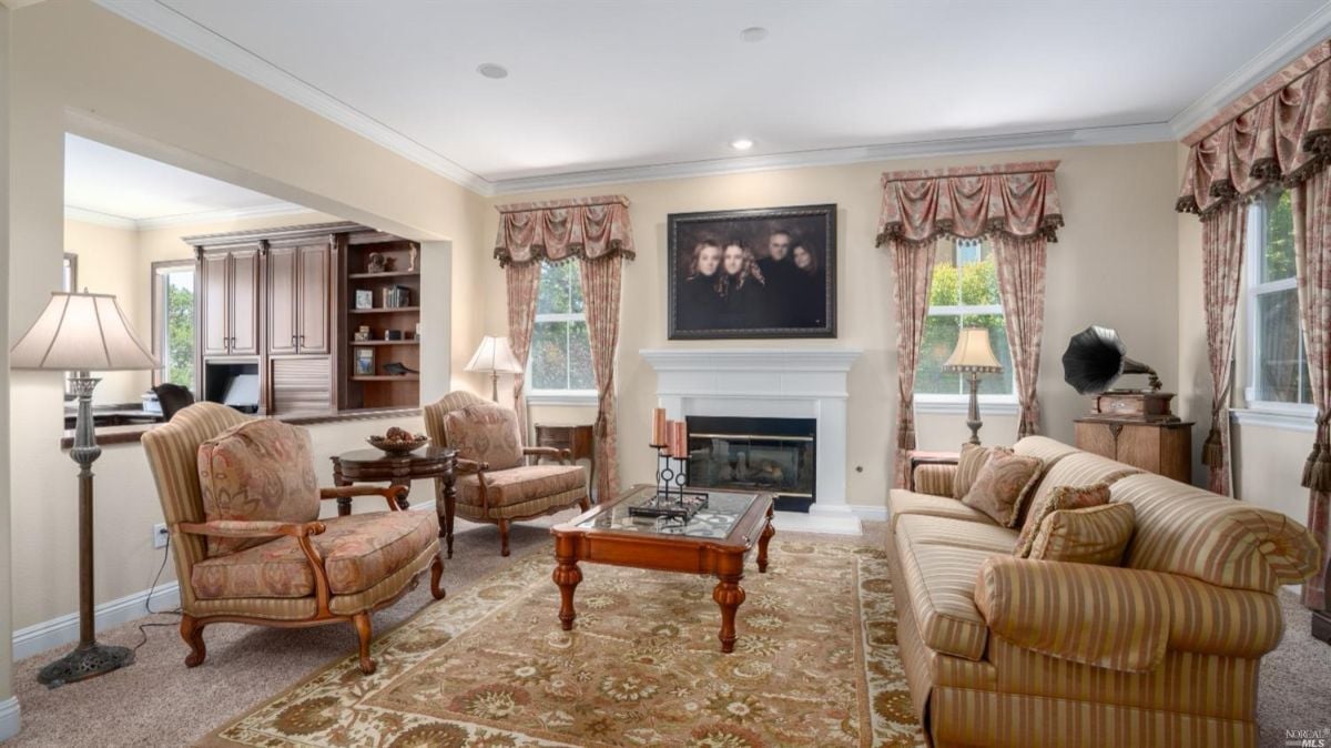 Living room with carpet flooring couches, and a fireplace.