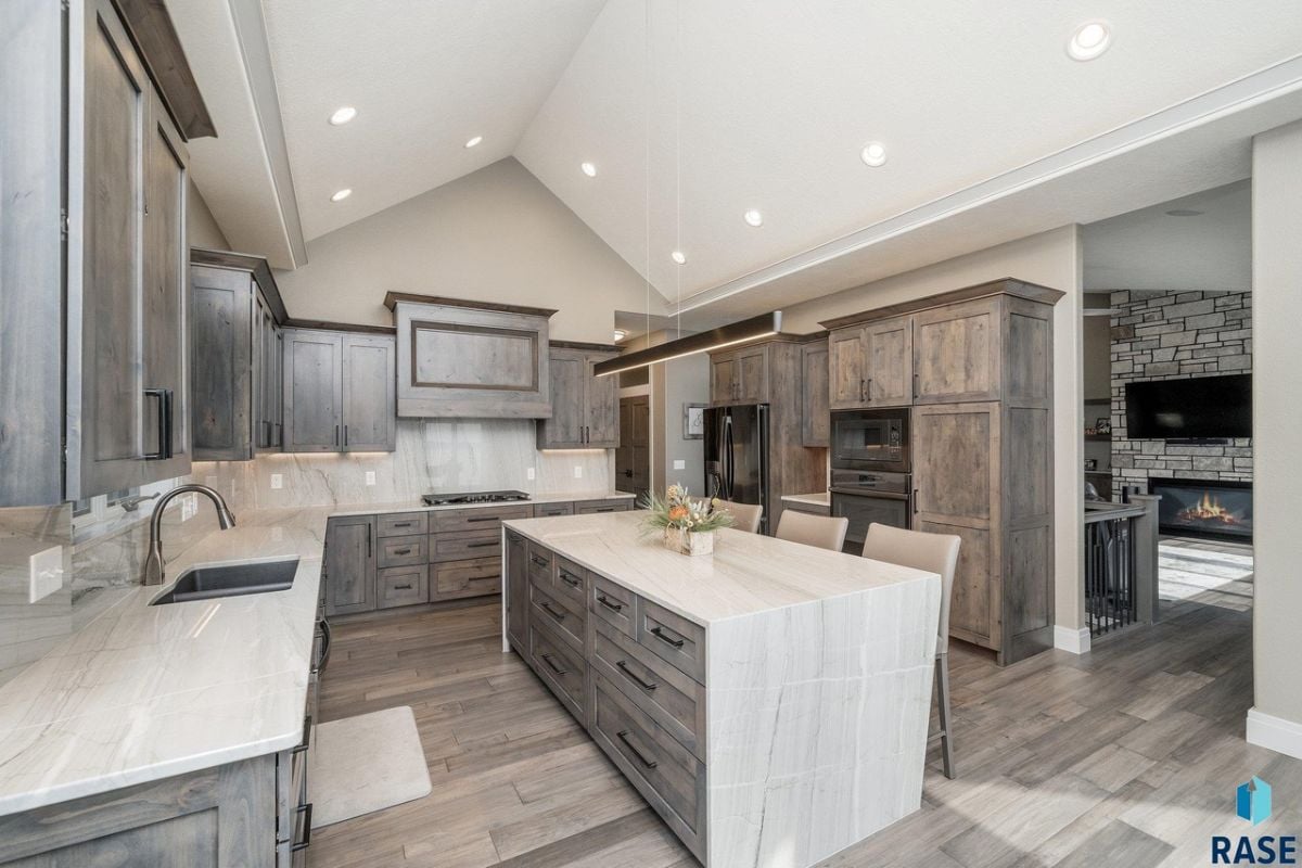 Kitchen with a large island, custom lighting, and custom cabinetry.
