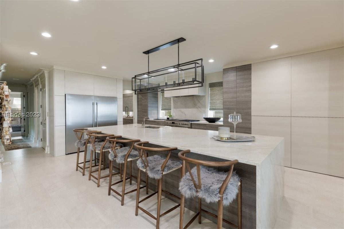 Kitchen with high-end stainless steel appliances, tile flooring and custom lighting.