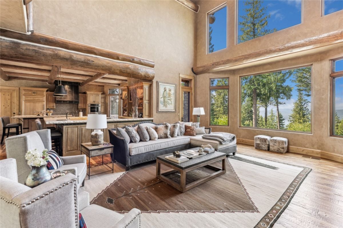 Living room with a couch. huge glass windows, and wood flooring.