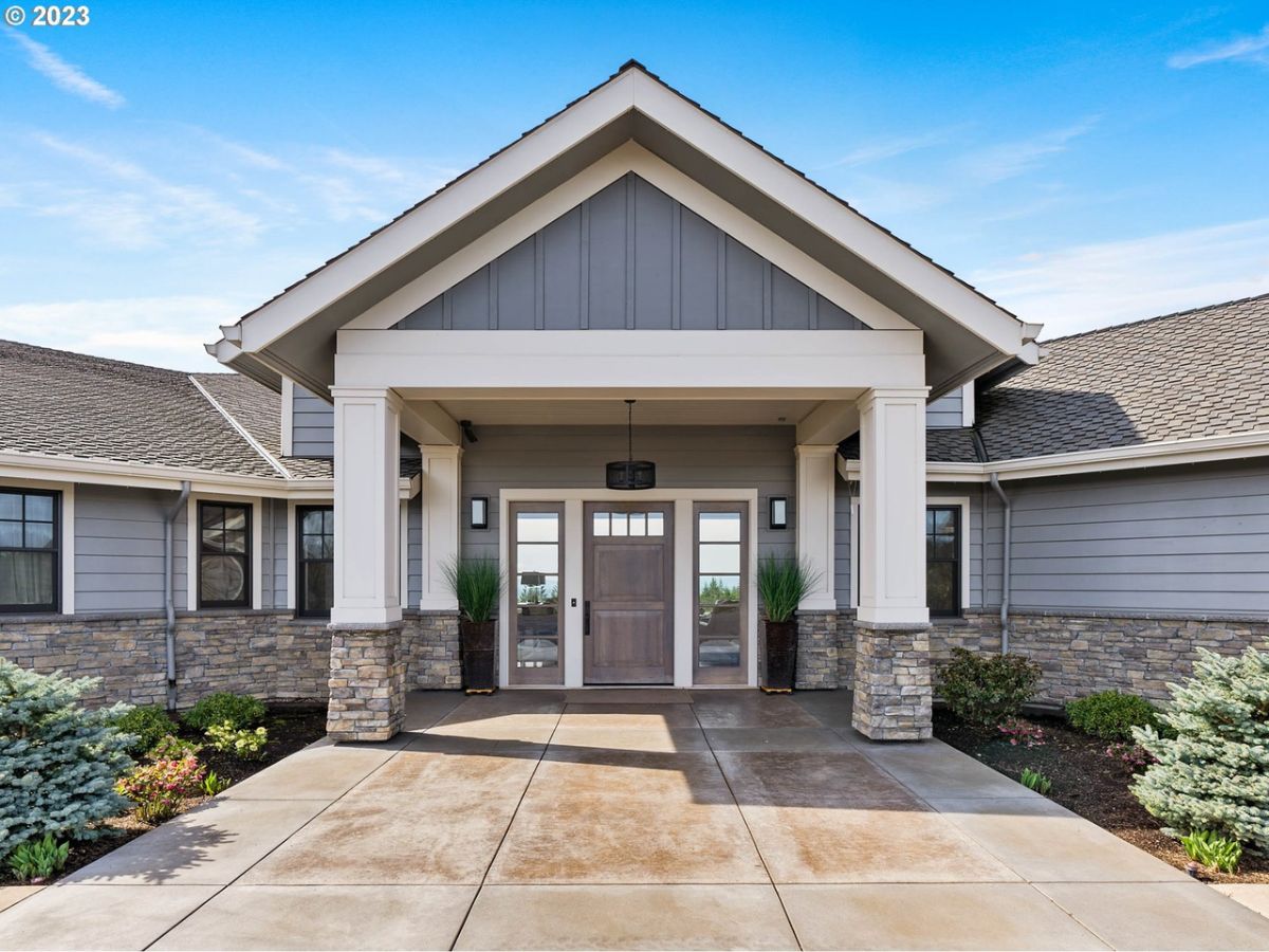 Formal entry of the house with a porch and a wooden door.