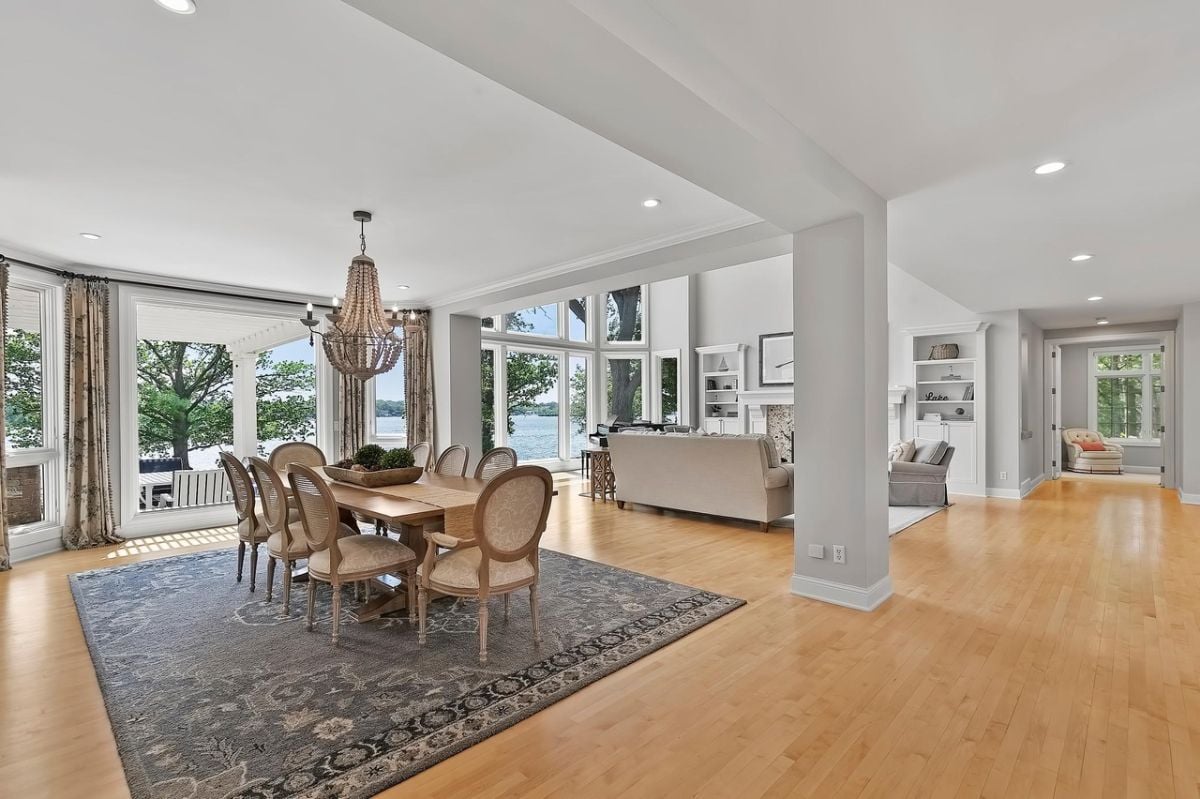 Dining room with chandelier, wood flooring, wooden table and chairs.