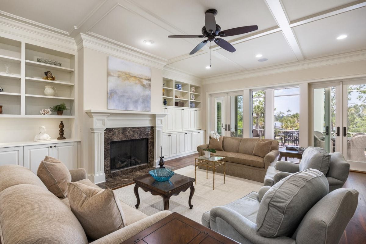 Living room with couches, custom lighting and a fireplace.