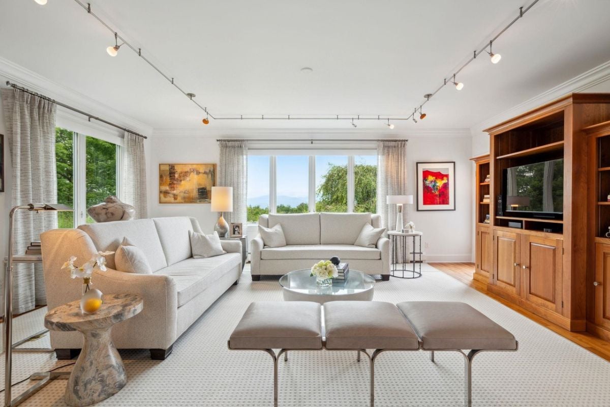 Living room with couches, TV, and custom lighting.