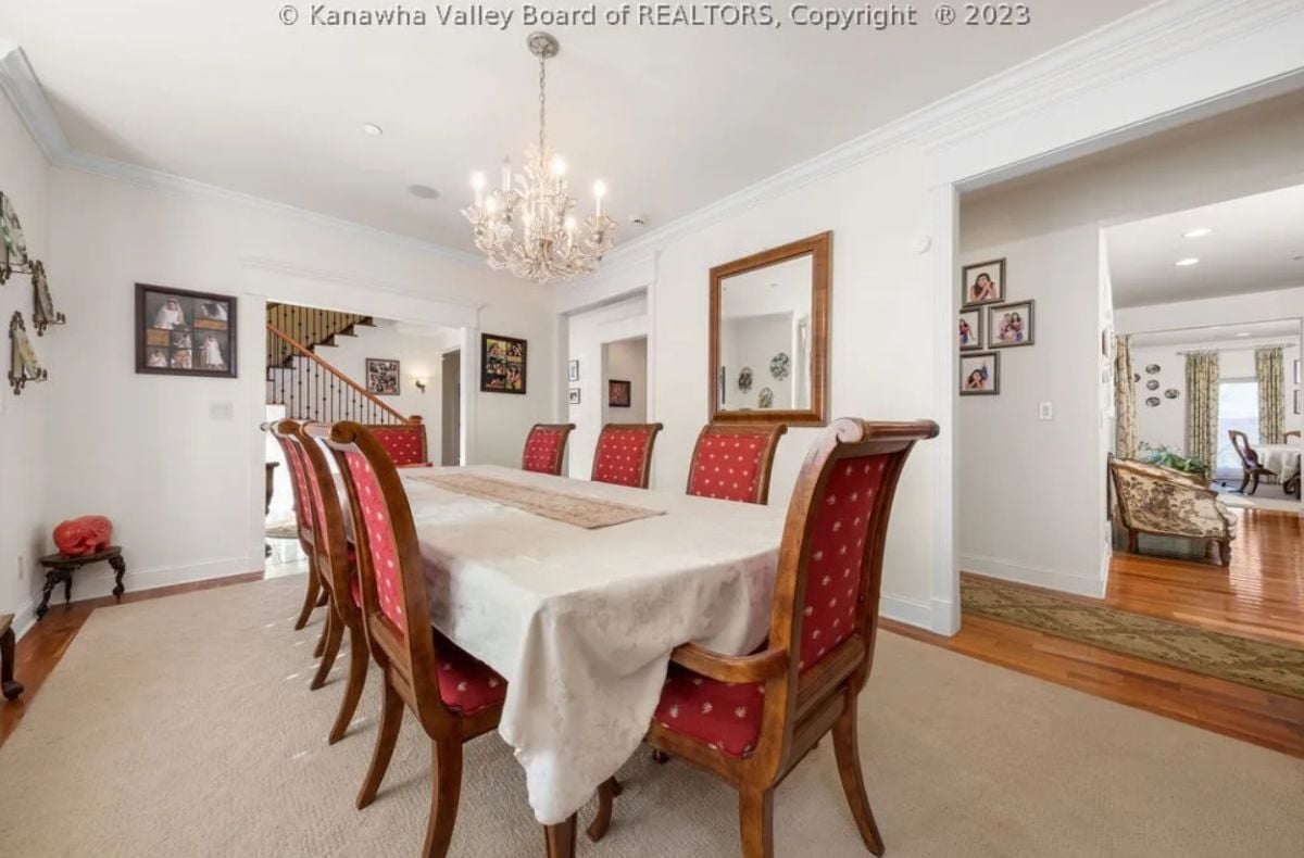 Dining room with a chandelier and a large table.