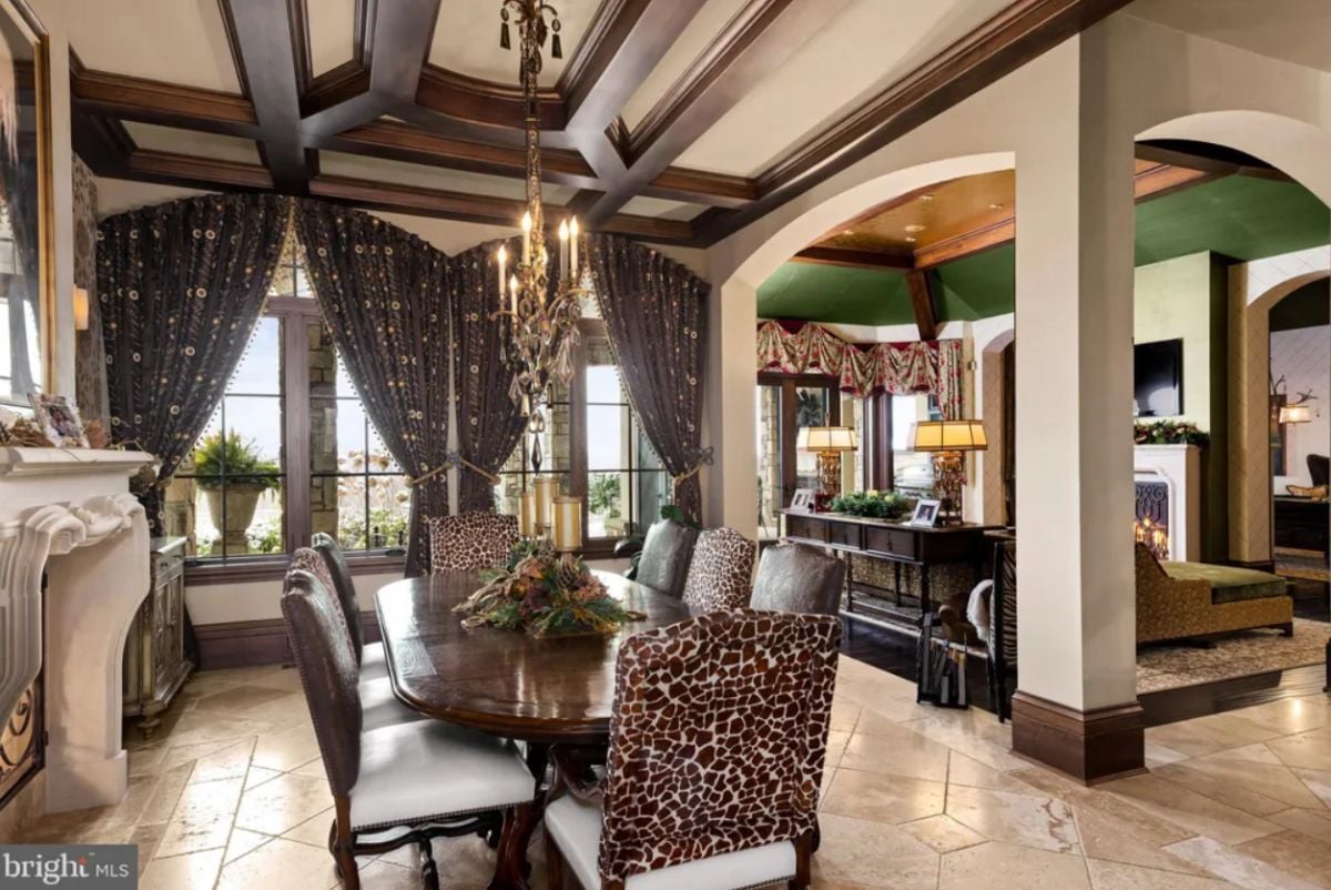 Dining room with a chandelier, a fireplace and a wooden table.