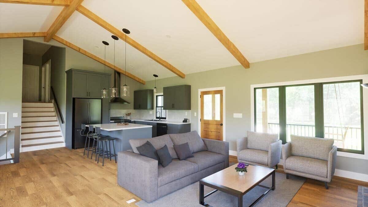 Family room and kitchen with hardwood flooring and a vaulted ceiling highlighted by exposed wood beams.
